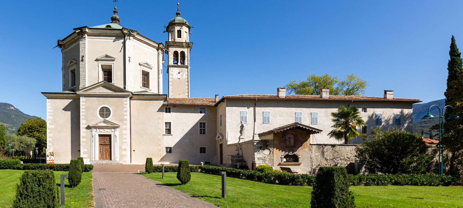 Church of the Inviolata, Riva del Garda. The linear exterior, with clean geometries, hides a Baroque soul. There are no people in the photograph. The church door is closed. Everything seems silent, at peace.