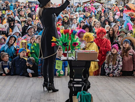 La foto mostra la maga Lilian durante un suo spettacolo di magia con un ricco pubblico di bambini incantati davanti a lei